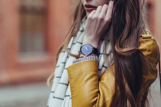 Žena v žltej bunde má na ruke výrazné hodinky.jpg